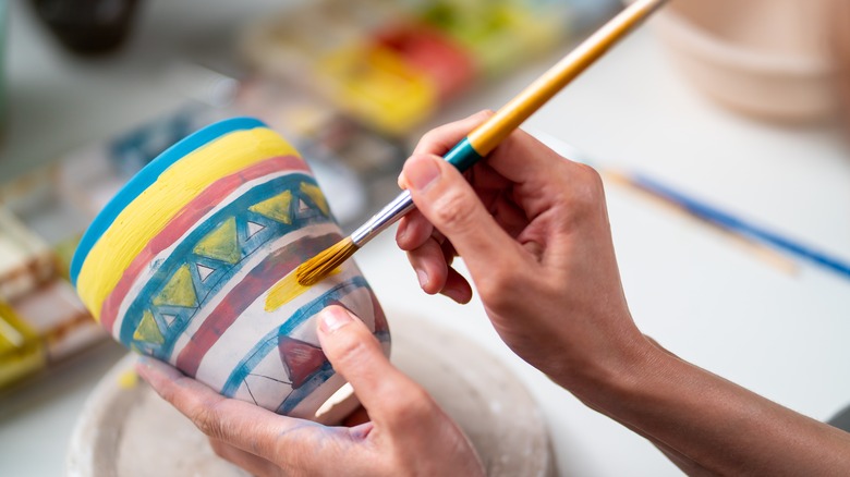 Woman painting pottery