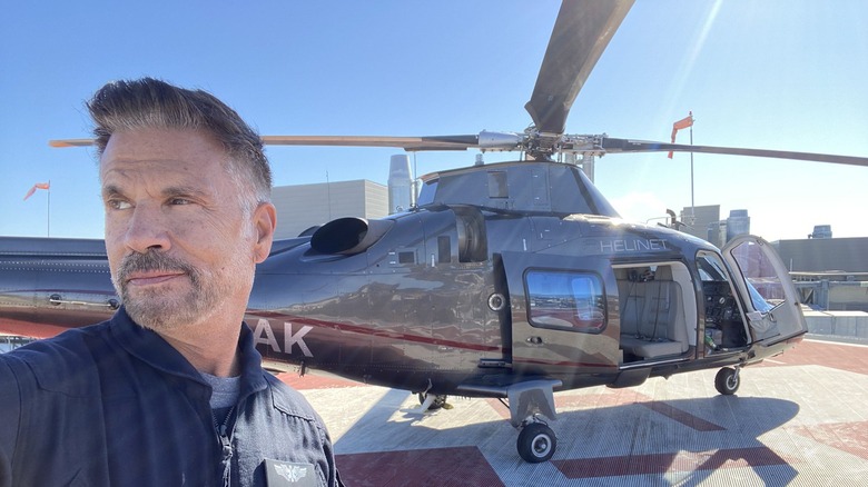 Lorenzo Lamas posing for a selfie in front of a helicopter in 2021.