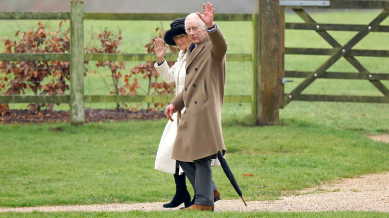 King Charles and Queen Camilla waving outside of church at Sandringham