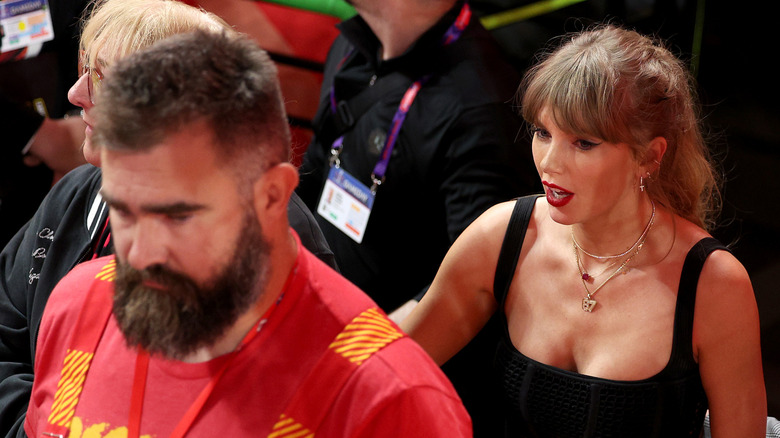 Jason Kelce walking in front of Taylor Swift