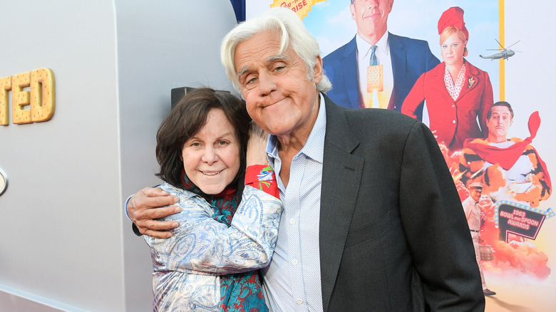 Jay Leno and his wife Mavis Leno smiling while embracing at an event
