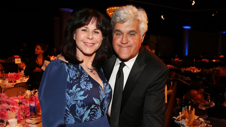 Jay Leno and Mavis Leno smiling while embracing at an event