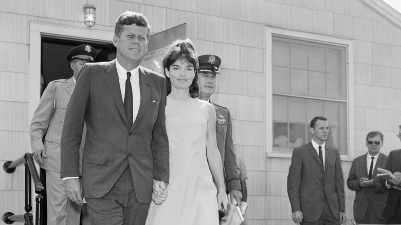 John F. Kennedy holding hands with Jackie Kennedy after she left the hospital after Patrick Kennedy died