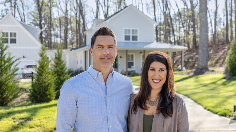 Ken and Anita Corsini posing in front of house