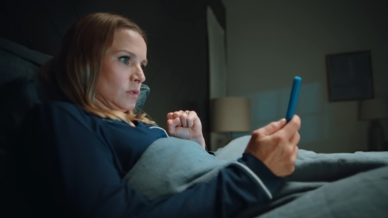 Kristen Bell looking at her phone in a Carvana commercial 