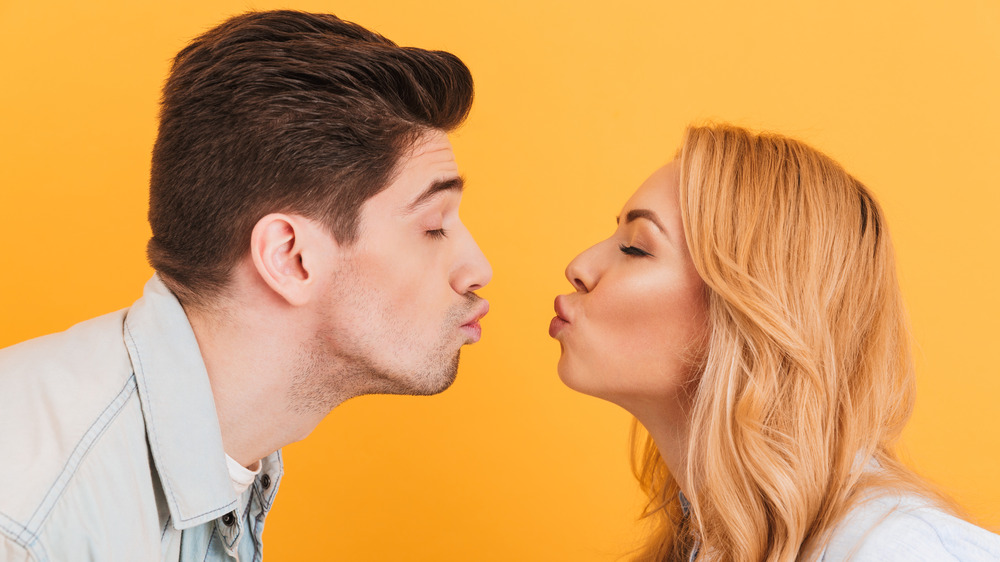 A couple leans in for a kiss, which transfers bacteria