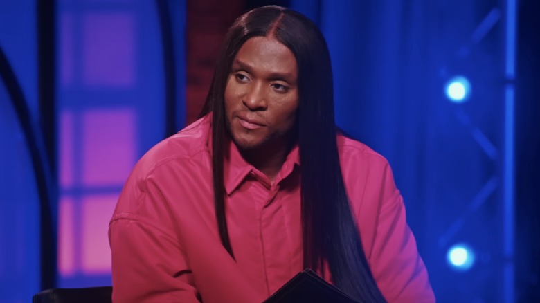 Law Roach, wearing bright pink, looking to the side while judging on "Project Runway"