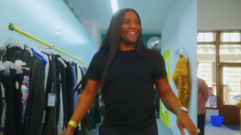 A smiling Law Roach browsing clothes in a Berlin vintage store