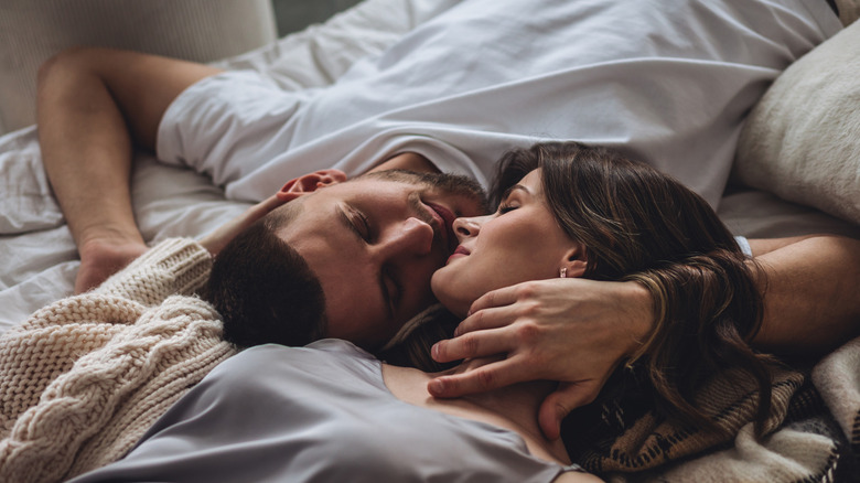 couple kissing in bed