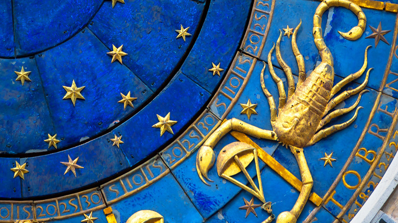 Golden scorpion on blue celestial background 