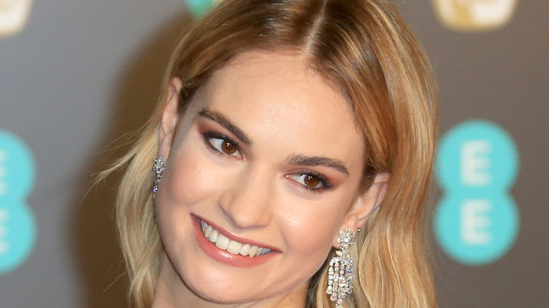 Lily James smiling with diamond earrings at BAFTA
