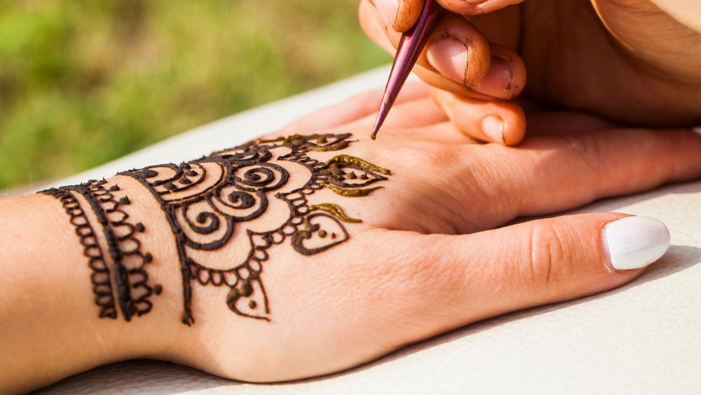 Woman getting a henna tattoo done