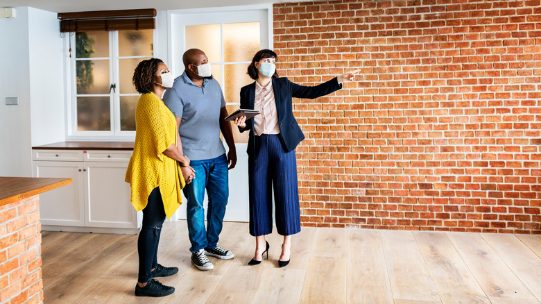 couple and realtor looking at a house