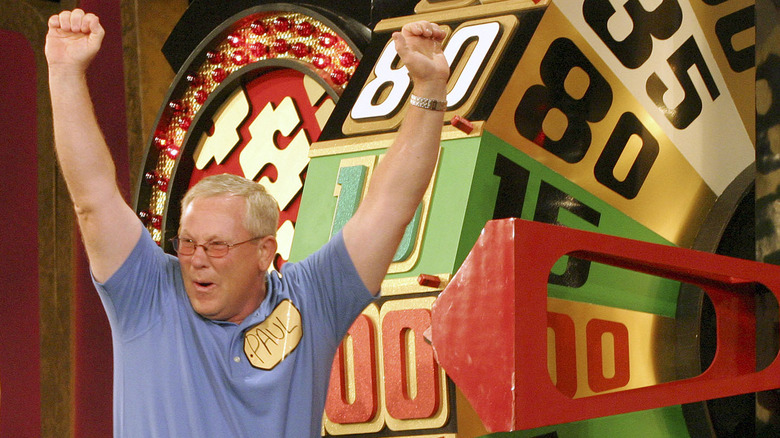 A Price is Right contestant cheers as he spins the wheel