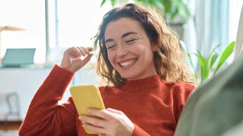 smiling woman looking at phone