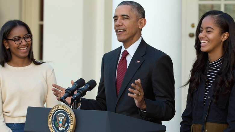 Malia, Sasha, and Barack Obama smiling 