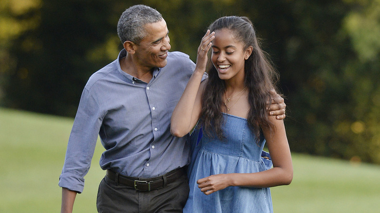 Barack Obama walking with arm around Malia Obama