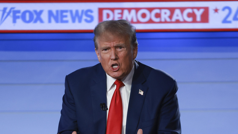 President Donald Trump gesturing, mouth open, in front of Fox News banner