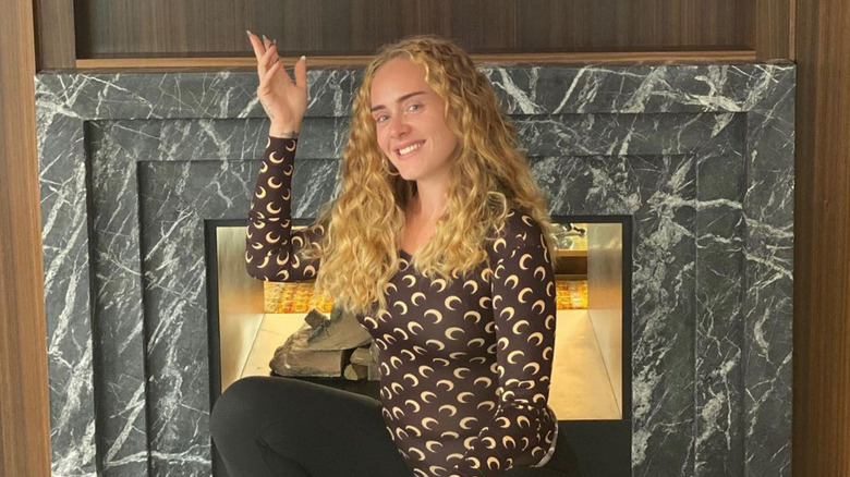 Adele posing by her fireplace