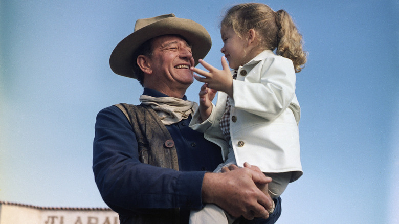 John Wayne holding his daughter Aissa