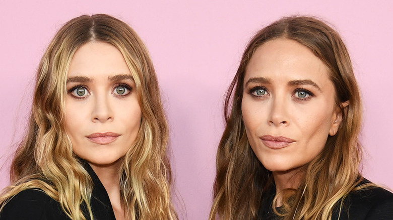 Mary-Kate and Ashley Olsen pose together at an event