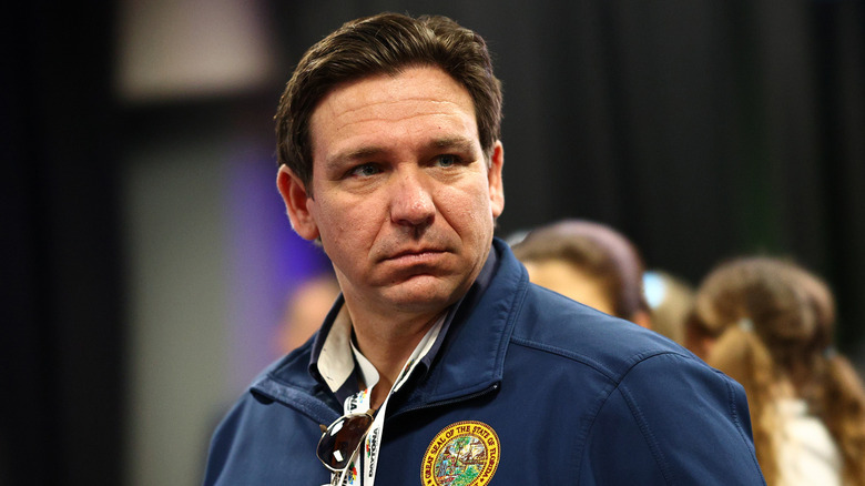 Ron DeSantis looking grumpy in a navy jacket