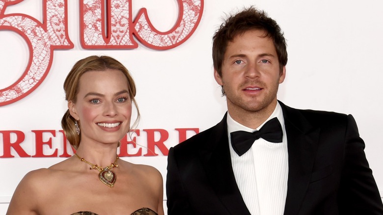 Margot Robbie and Tom Ackerley smiling at the Wuthering Heights premiere