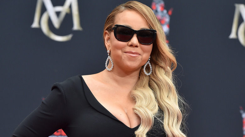 Mariah Carey wearing a black dress and sunglasses