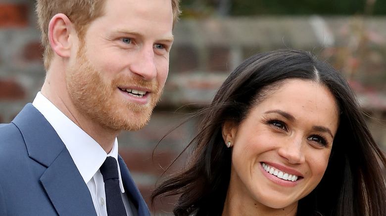 Prince Harry and Meghan Markle smile for a photo. 
