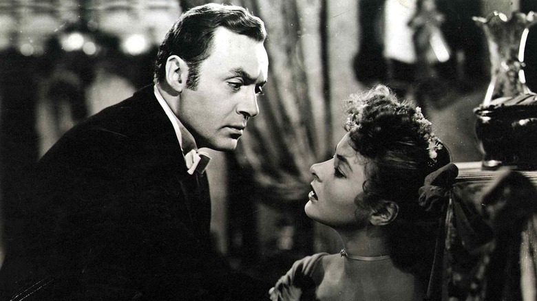 "Gaslight" 1944 film still: Charles Boyer leans over ingrid bergman