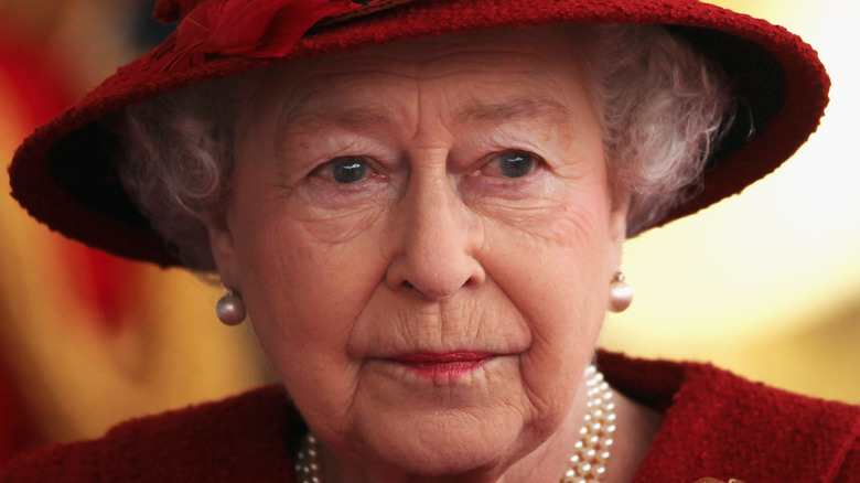 Queen Elizabeth in red hat and pearls