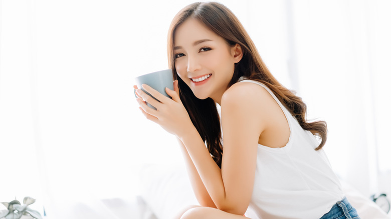 young woman holding mug of coffee