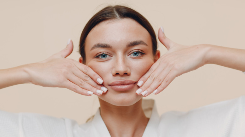 Woman lifting her hands over her face