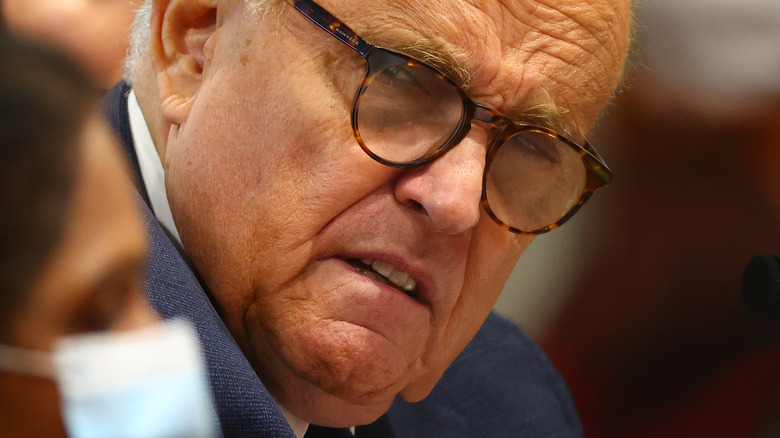 Rudy Giuliani wearing glasses and squinting