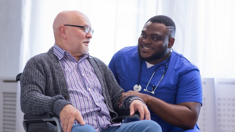 nurse helping a man in a wheelchair