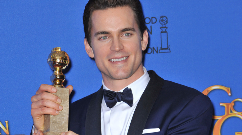 Matt Bomer holding his Golden Globe