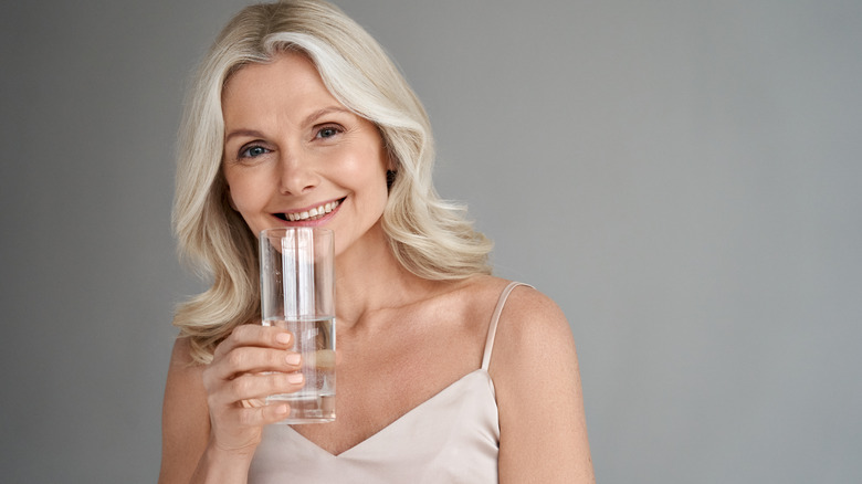 Older woman holding a glass of water
