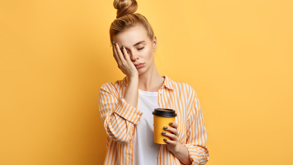 Sad woman holding coffee cup