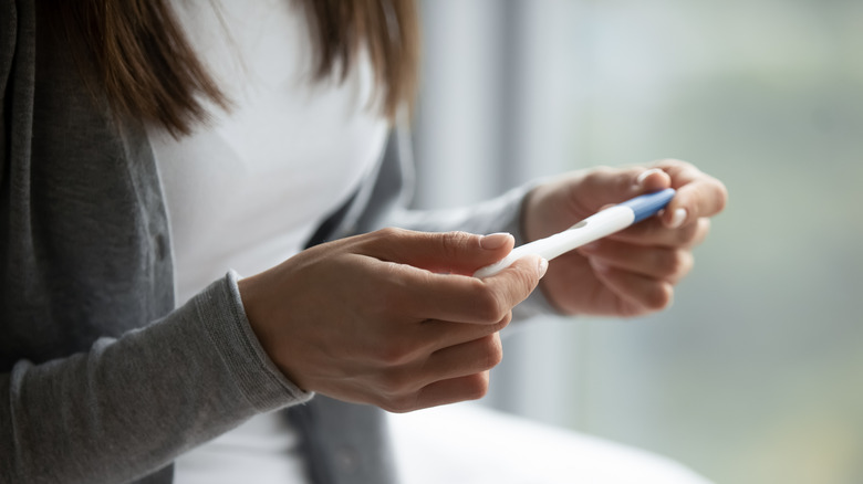 woman holding pregnancy test