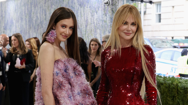 Sunday Rose wearing an embellished fuzzy strapless dress with Nicole Kidman wearing a sparkly red dress at a red carpet event.