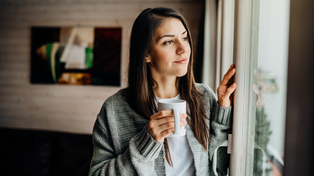 Young woman staring out window