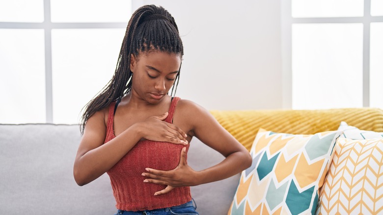 young woman doing self breast exam