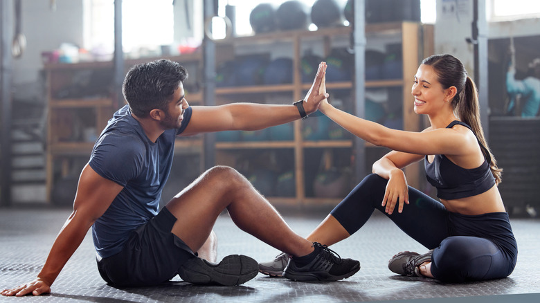 A couple high-fiving at the gym