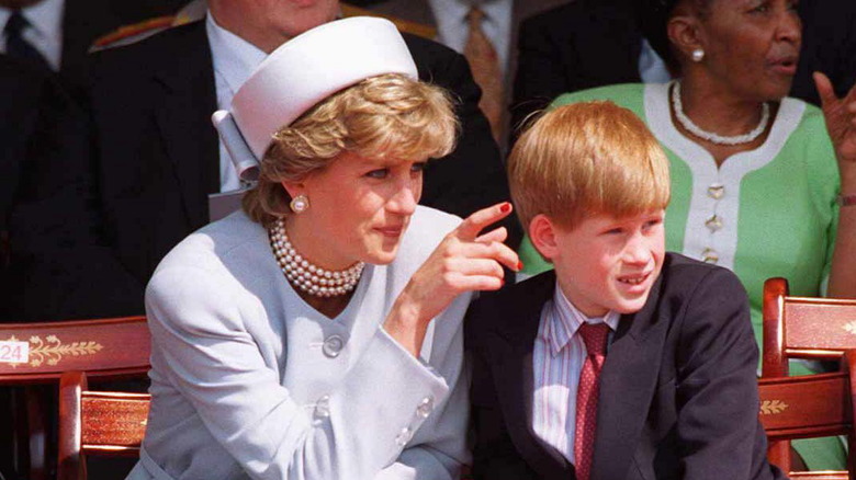 Princess Diana pointing something out to a young Prince Harry