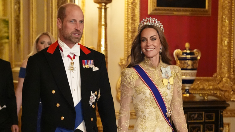 Princess Catherine and Prince William walking through Buckingham Palace hallway