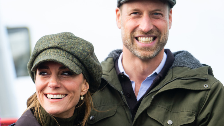 A smiling Princess Catherine and Prince William in complementary green clothing