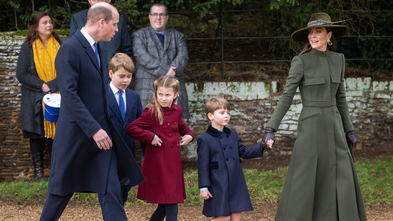 Prince William and Princess Catherine on a walkabout with their three kids
