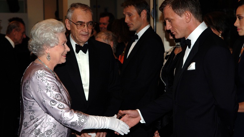 Queen Elizabeth II shaking Daniel Craig's hand at the premiere of James Bond Happy and Glorious