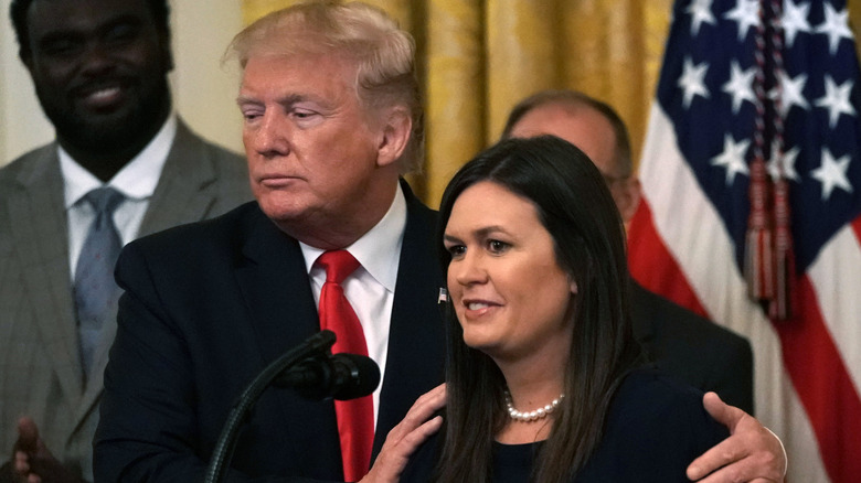 Donald Trump holding onto Sarah Huckabee Sanders