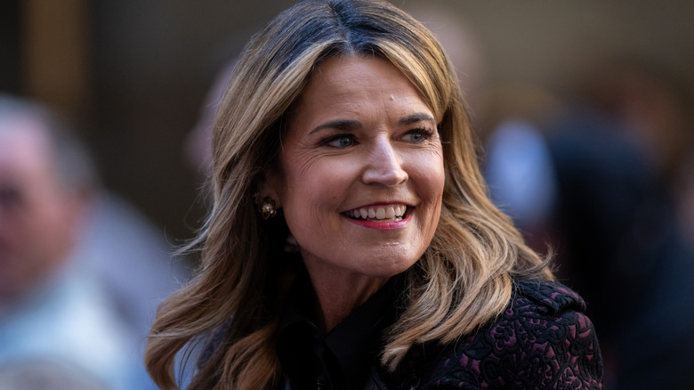 Savannah Guthrie smiling while looking over her shoulder